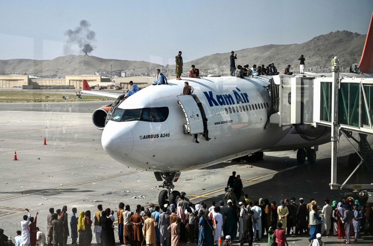 کئی افغان شہری بھی کابل چھوڑنے کیلئے ائیرپورٹ پر موجود ہیں اور کئی طیاروں پر لٹکنے کی کوشش کررہے ہیں— فوٹو: اے ایف پی
