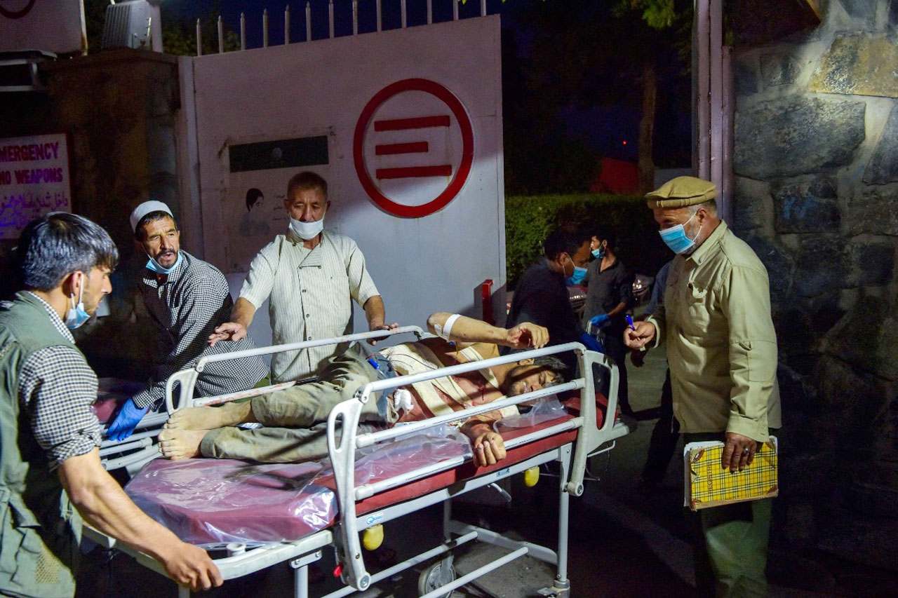 کابل ائیرپورٹ حملے میں زخمی ہونے والے ایک شخص کو اسپتال منتقل کیا جارہا ہے — فوٹو: اے ایف پی