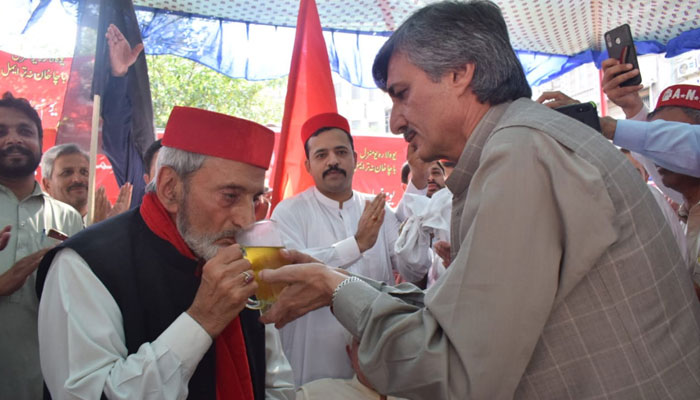 بعدازاں آج ہڑتال کے دوسرے روز اے این پی رہنما سردار حسین بابک  نے سینیئر رہنما حاجی غلام احمد بلور کی بھوک ہڑتال ختم کرائی اور انہیں جوس پیش کیا— فوٹو: اے این