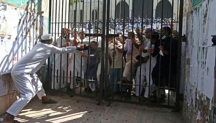 مشتعل مظاہرین دروازہ کھول کر اندر داخل ہونے کی کوشش کر رہے ہیں۔ فوٹو: سوشل میڈیا