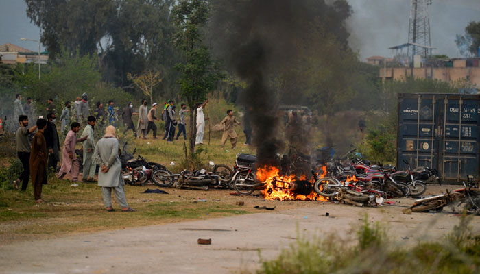 تحریک انصاف کے کارکنوں کی جانب سے درجنوں موٹر سائیکلوں کو بھی آگ لگائی گئی — فوٹو: اے ایف پی