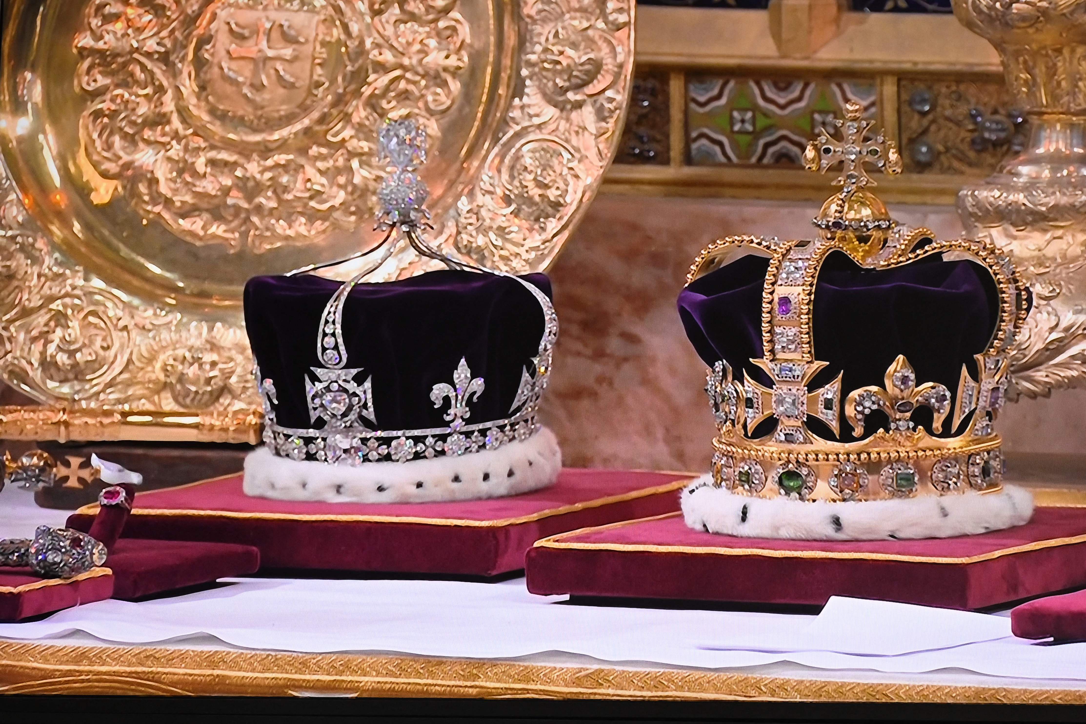 King Charles' 360-year-old crown (right) is over 30cm long and weighs over two kilograms, while Queen Camilla's crown is on the other side.