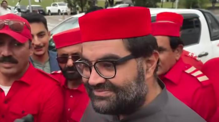 ایمل ولی سرخ کپڑوں میں ملبوس پارٹی گارڈز کی حفاظت میں پارلیمنٹ ہاؤس پہنچ گئے